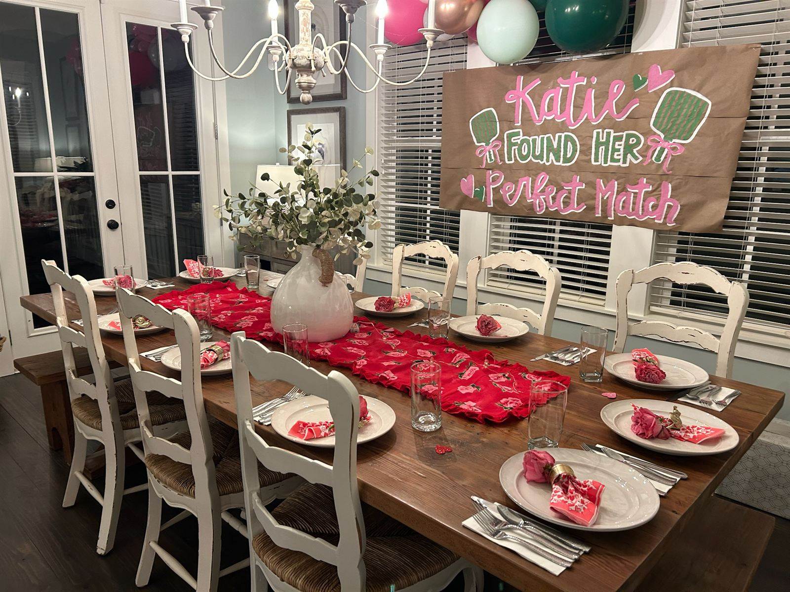 Dinner table set under a banner celebrating an engagement
