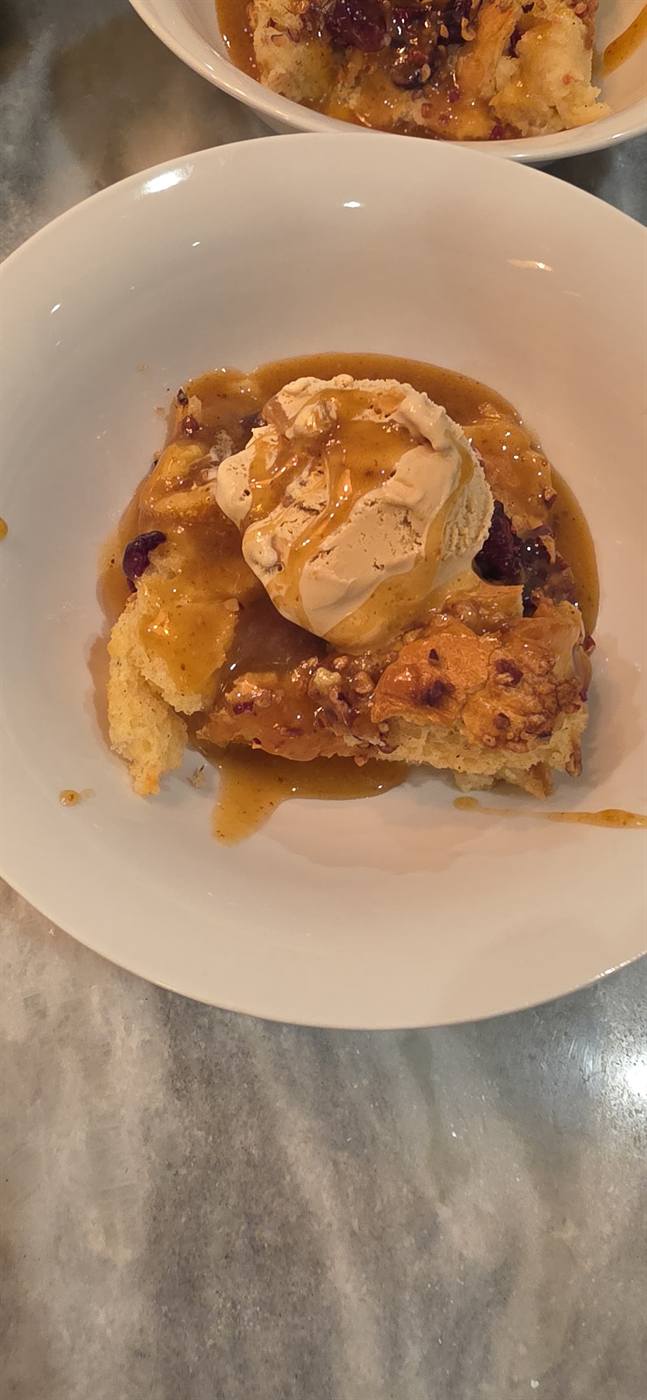 Bourbon pecan bread pudding served warm with cream