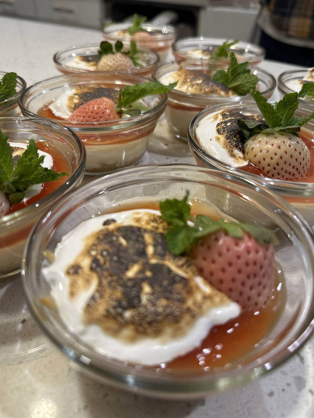 Banana pudding cups finished with torched meringue and strawberries