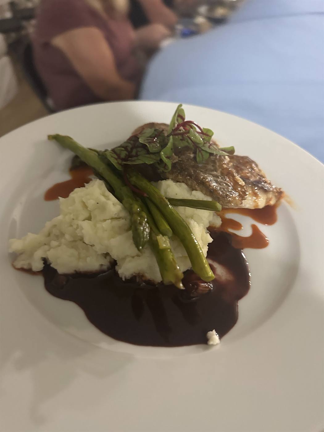 Roasted garlic mashed potatoes plated with asparagus and pan sauce